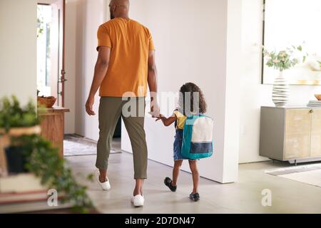 Rückansicht Von Vater Hält Töchter Hand, Wie Sie Geht Zuhause Für Die Schule Stockfoto