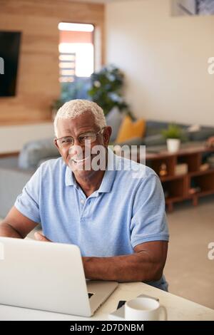 Portrait Of Senior African American Man Using Laptop To Check Finanzen Zu Hause Stockfoto