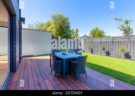 Esstisch im Freien auf Holzterrasse in einem Vorstadthaus Hinterhof in Australien Stockfoto