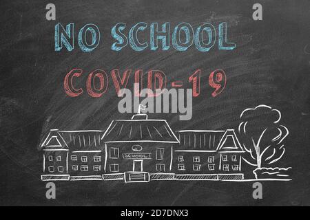 Schulgebäude und Schriftzug Keine Schule COVID-19 auf Tafel. Handgezeichnete Skizze. Coronavirus-Konzept. Stockfoto