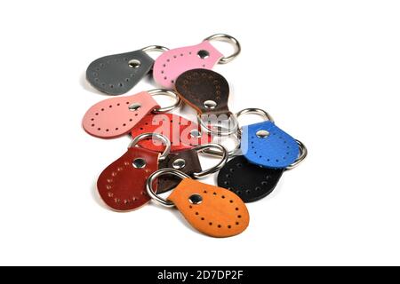 Leere runde Farbe Leder Schlüsselanhänger Kollektion auf isoliertem weißem Hintergrund mit Clipping Pfad. Stapel Set von metallischen Souvenir. Stockfoto