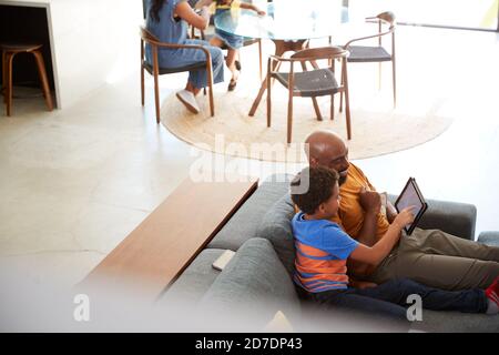Afroamerikanische Familie Zu Hause Mit Vater Und Sohn Sitzen Auf Sofa Zu Hause Mit Digitalem Tablet Stockfoto