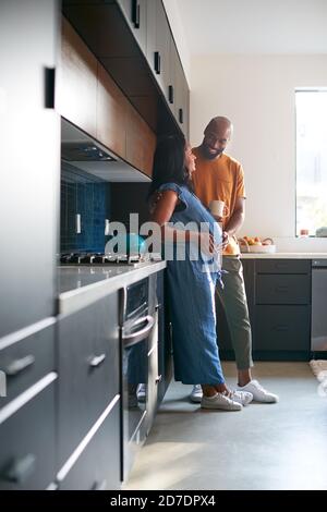 Loving Afrikanisch Amerikanisch Mann Mit Schwanger Frau Zu Hause In Küche Zusammen Stockfoto