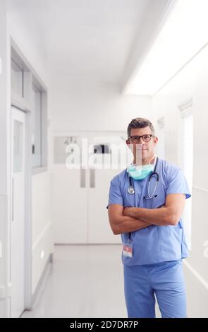 Portrait Von Reifen Männlichen Arzt Tragen Scrubs Im Krankenhaus Stehen Korridor Stockfoto