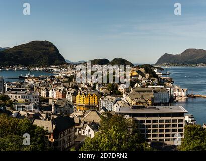 Blick auf Ålesund in Norwegen an einem sonnigen Tag mit Bergketten im Hintergrund mit Wasser herum Stockfoto