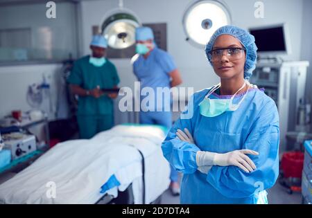 Portrait Der Weiblichen Chirurgen Trägt Scrubs Und Schutzbrille In Operationssaal Des Krankenhauses Stockfoto