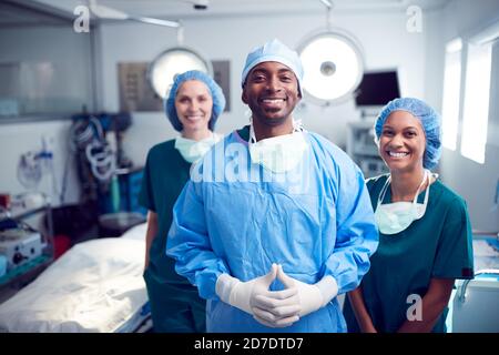 Portrait Des Multi-Cultural Surgical Teams, Das Im Operationssaal Des Krankenhauses Steht Stockfoto