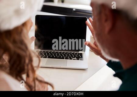 Ältere Hispanische Paar Trägt Santa Hüte Mit Laptop Mit Video Chatten Sie Mit Der Familie Zu Weihnachten Stockfoto