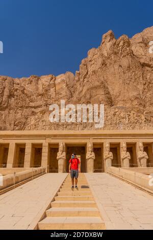 Vertikale Aufnahme eines kaukasischen Mannes, der im Totentempel der Hatschepsut, Ägypten, reist Stockfoto