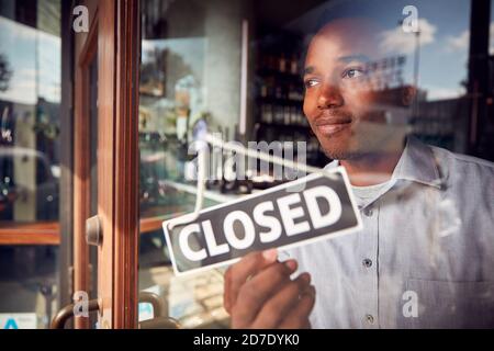 Männlicher Besitzer Des Coffee Shops Oder Restaurants, Der Rund Dreht, Ist Geschlossen Melden Sie Sich An Der Tür Des Fehlgeschlagenen Geschäfts An Stockfoto