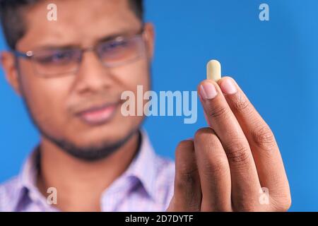 Besorgt junger Mann Hand hält Pille Stockfoto
