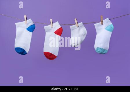 World Preaturity Day Konzept. Normale Größe und winzige Socken am Seil mit violettem Hintergrund Stockfoto