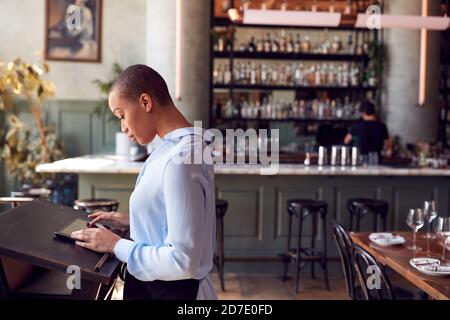 Weibliche Inhaberin Der Restaurant Bar Steht An Der Theke Mit Digital Tablet Stockfoto