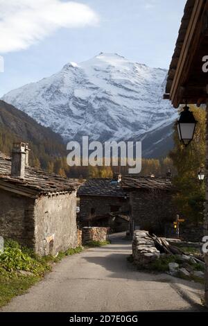 Landschaft : Le Villaron Dorf mit traditionellen Steinhäusern, Kamin und Straßenlaterne, verschneiten Berg im Hintergrund Pointe de Charbonnel Stockfoto
