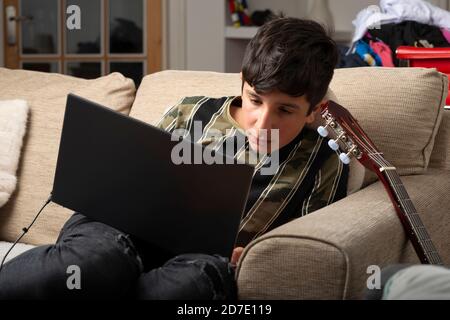 Teenager, Alter 13-14 auf seinem Laptop zu Hause Stockfoto