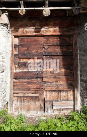Traditionelle Holztür eines Steinhauses in Le Villaron Village Haute-Maurienne Savoie Frankreich Stockfoto