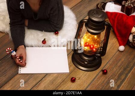 Mädchen schreibt Pen auf ein Stück Papier zu Weihnachten wünschen und Briefe zu Sankt Stockfoto