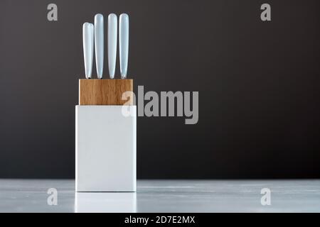 Küchenmesser Set in weißem Halter auf dem weißen Tisch, Nahaufnahme Stockfoto