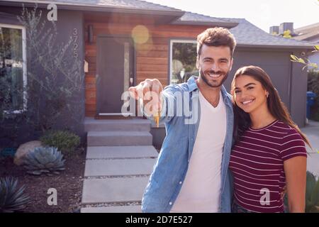 Porträt Des Paares Steht Im Freien Vor Dem Haus Mit Zum Verkauf Anmelden Garden Holding Keys Stockfoto