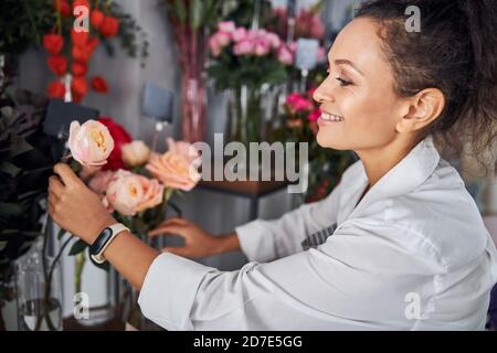 Erfahrene Floristen, die Blumen in einer Vase aussortieren Stockfoto