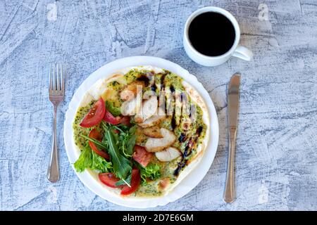 Italienisches Frühstück mit Kaffee. Piadina mit gegrilltem Hähnchen, Tomaten, Salat und Rucola. Leckeres Frühstück. Weichfokus. Draufsicht Stockfoto