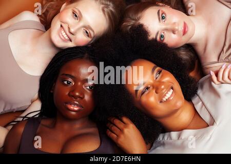 Junge hübsche kaukasische, afro, skandinavische Frau posiert fröhlich zusammen auf braunem Hintergrund, Lifestyle diverse Nationalität Menschen Konzept Stockfoto