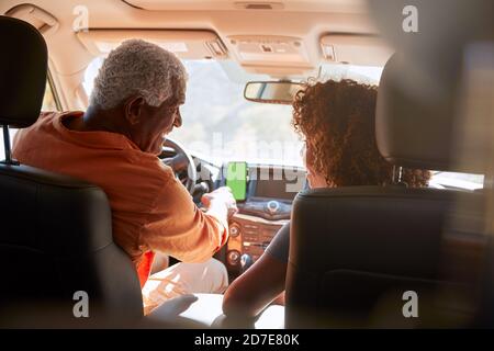 Senior African American Paar Auf Fahrt Durch Die Landschaft Mit Sat Nav Auf Dem Mobiltelefon Stockfoto