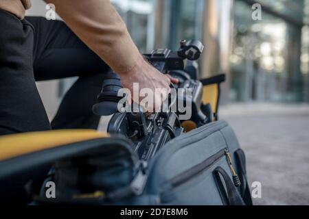 Nahaufnahme der männlichen Hände, die die Kamera aus dem Gehäuse nehmen Stockfoto