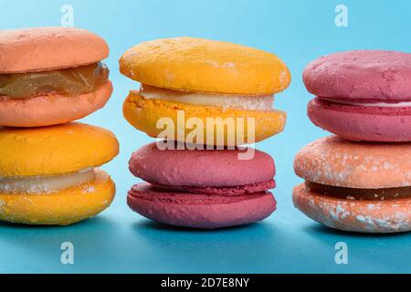 Bunte Makronen auf hellblauem Hintergrund gestapelt. Französisch süß mit Mandelmehl in seinem Rezept. Stockfoto