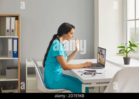 Seitenansicht der Hausärztin Frau mit Laptop für Online-Konsultation mit ihren Patienten. Stockfoto
