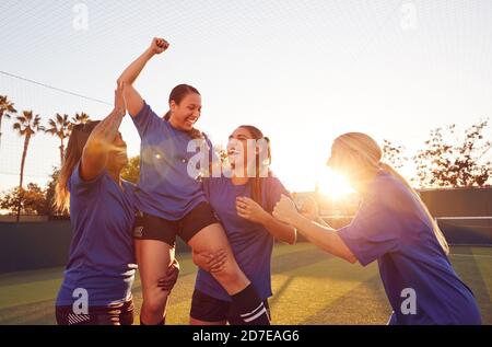 Damen Fußballteam Feiert Das Siegreiche Fußballmatch, Das Spieler Auf Die Straße Hebt Schultern Stockfoto