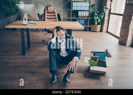 Über hohen Winkel Ansicht seiner er deprimiert verzweifelte Arbeitslosen Guy Anwalt Rechtsanwalt sitzt auf dem Boden mit Kartons Habseligkeiten Dinge im modernen Loft Stockfoto