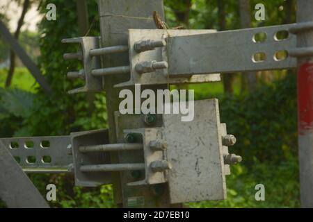 Nahaufnahme der Muttern und Schrauben, die zwei Stahlplatten auf einem Stahlstock verbinden, selektive Fokussierung Stockfoto