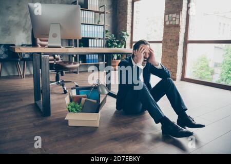 Foto von entlassen traurigen Arbeiter reifen Kerl scheitern Gefeuert Agent verloren Job verpackt Habseligkeiten Box Finanzkrise sitzen Boden Holzparkett hoffnungslos Stockfoto