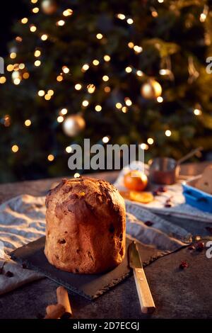 Traditionelle Weihnachten Panettone Auf Tisch-Set Für Festliche Mahlzeit Mit Baumlichter Im Hintergrund Stockfoto