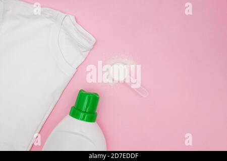 Waschflüssigkeit, Waschpulver und sauberes T-Shirt auf rosa Hintergrund Stockfoto