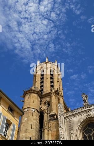 Die Fundamente für den 64 Meter (210 ft) Glockenturm der Cathédrale de St.-Sauveur in Aix-en-Provence, Provence-Alpes-Côte d’Azur, Frankreich, wurden 1323 gelegt, aber er wurde erst 1430 mit Glocken vollendet. Der Turm ragt über die façade Westfassade der Kathedrale am Place de l’université, mit seinem quadratischen Sockel, der von einem achteckigen, extravaganten gotischen Turm überragt wird, der von gehäkelten Zinnen gekrönt wird. Die Kathedrale selbst ist viel älter. Es wurde 1103 eingeweiht, aber das erste christliche Oratorium hier wurde um 500 n. Chr. auf einer vorrömischen heiligen Stätte durch einen römischen Tempel des Apollo ersetzt gegründet. Stockfoto