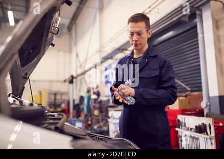 Male Motor Mechanic Wischen Hände Nach Der Arbeit An Auto-Motor In Der Garage Stockfoto