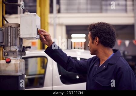Male Motor Mechanic Heben Auto Auf Hydraulic Lift In Garage Stockfoto