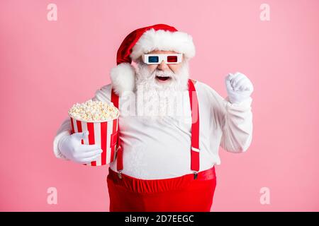 Porträt seiner er schön attraktiv fröhlich fröhlich froh bärtig Fat Santa beobachten Comedy Film Essen Mais Spaß Zeitvertreib Amusement isoliert rosa Stockfoto