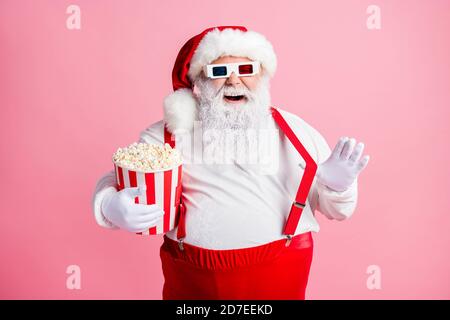 Portrait von seinem er schön attraktiv fröhlich fröhlich lustig bärtig Fat Santa Film zu essen Mais mit Spaß amüsant ziehen Hosenträger täuschen Stockfoto