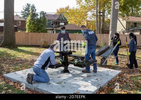 Detroit, Michigan - Freiwillige von CooperStandard installieren Picknick-Tische und tun Landschaftsbau in einem Stadtpark in der Morningside Nachbarschaft. Der Park i Stockfoto