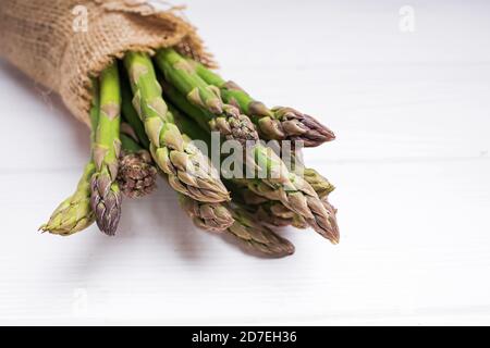 Bund frischer grüner Spargel auf weißem Tisch Stockfoto