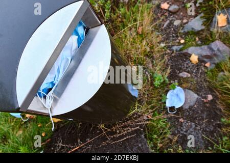 Die verwendeten Gesichtsmasken in der Mülltonne während der COVID-19 Pandemie in Finnland. Stockfoto