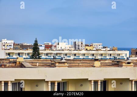 Hoteldächer und unfertige Häuser in einer arabischen Stadt im Nahen Osten. Die oberen Etagen von unfertigen Gebäuden in Tunesien in der Nähe des Mittelmeers. Stockfoto