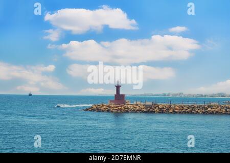 Schiffe in der Nähe der Hafeneinfahrt. Das Wellenbrecher und der wolkige Himmel - Tunesien, Sousse, El Kantaoui 06 19 2019 Stockfoto