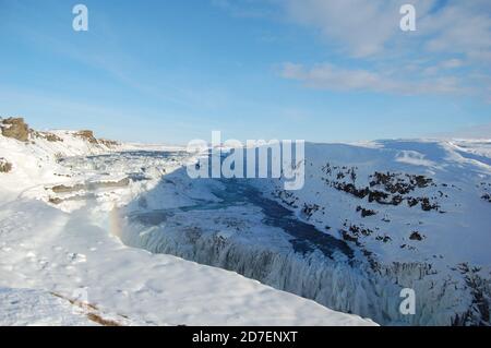 Gullfoss Wasserfall Panoramablick in Island im Winter bedeckt Durch Schnee und Regenbogen und blau klaren Himmel oben Stockfoto