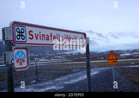 Straßenschild im Vordergrund, der zur Gletscherlagune führt Svinafellsjokull in Island im Hintergrund Winterzeit Stockfoto