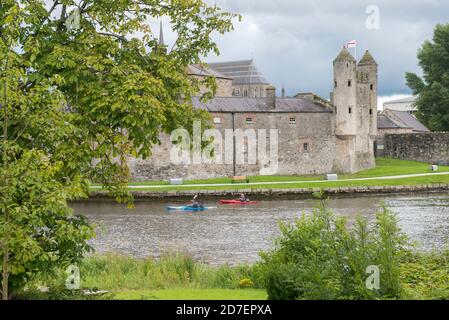 Ein Kajakfahrer paddelt am Enniskillen Castle in der Grafschaft Fermanagh, Nordirland, Großbritannien vorbei Stockfoto