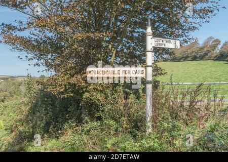 Altes Straßenschild im ländlichen Stil mit Schild "undurchführbar für Autos" in der Nähe von St. Winnow, Cornwall. Landstraße nicht geeignet für Autos, Offroad, unebene Strecke. Stockfoto